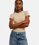 Body femenino color beige, confeccionado en malla de poliamida, con cuello redondo, mangas cortas y cierre de broches en la entrepierna.