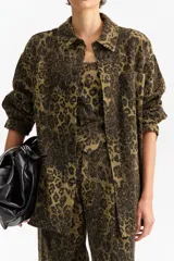Sobrecamisa de manga larga, cuello camisero y silueta relajada, confeccionada en tejido texturado con estampado animal print de leopardo en tonos verde militar y negro.