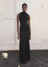 Vestido largo negro de punto fino, con cuello perkins y diseño sin mangas. Presenta un diseño entallado en la parte superior y falda evasé combinada de lyocell.