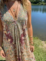 Vestido largo estampado paisley en tonos terracota, beige y turquesa. Diseño con escote halter y caída fluida.