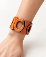 Pulsera elástica de resina con diseño de piezas ovaladas en tonos marrones y anaranjados.