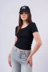 Remera blanca de manga corta, corte ajustado y escote redondo. Presenta un pequeño detalle de etiqueta negra en la manga izquierda.