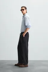 Pantalón de corte relajado color beige confeccionado en tejido de mezcla de algodón y lino. Posee cintura elástica ajustable con cordón, bolsillos frontales y bolsillos traseros de vivo.