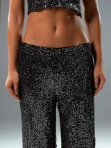 Pantalón largo de lentejuelas negras, de corte palazzo.