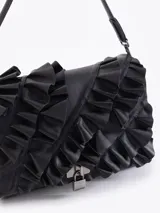 Cartera de hombro negra confeccionada en cuero vacuno, con diseño de solapa frontal decorada con volados de cuero y cierre metálico tipo candado.