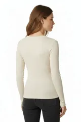 Remera de manga larga con cuello redondo a la base, confeccionada en tejido de algodón con elastano de textura acanalada.