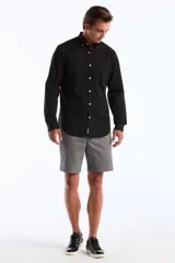 Camisa de hombre negra de popelina elástica, con cuello abotonado, manga larga y bolsillo en el pecho.