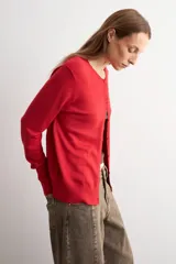 Cardigan de punto fino color negro, con cuello redondo, cierre frontal de botones y mangas largas.