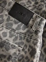 Minifalda de denim con estampado de leopardo en tonos grises y blancos, tiro medio, con cierre de cremallera y bolsillos delanteros y traseros.