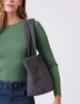 Bolso tipo tote de diseño capitoneado en color marrón, con doble asa para llevar al hombro y cierre mediante botón metálico. Cuenta con forro interno a tono y bolsillos organizadores en su interior.