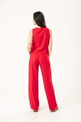 Pantalón rojo de lino imperial con lurex, tiro medio, corte recto, bolsillos delanteros y traseros, cierre frontal con cremallera y botón.