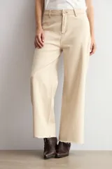 Jean de corte culotte y tiro medio, color beige, con diseño de perneras anchas y terminación desmechada en el bajo.