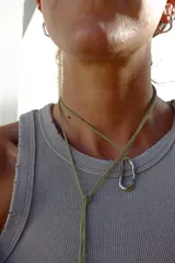 Collar con hilo de fibra de algodón natural color verde oliva y dije de bronce macizo con forma irregular.