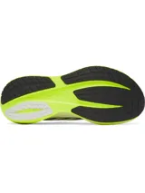 Championes de running Under Armour modelo Velociti Distance, con tecnología de amortiguación HOVR+ en la entresuela. Presentan un diseño técnico en color blanco con detalles en amarillo neón y negro, confeccionados en tejido de malla transpirable.