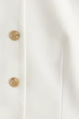 Chaleco de sarga de mezcla de algodón con escote de pico, botonadura sencilla y diseño con peplum acampanado en la parte inferior. Prenda forrada.