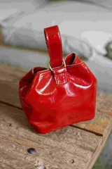 Mini limosnera roja charolada con manija corta.