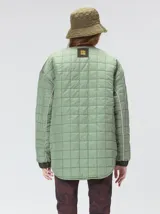 Campera reversible capitoneada con cierre frontal. Un lado es de color negro y el otro es de color beige, ambos con diseño acolchado. Cuenta con cuello redondo, mangas largas y bolsillos laterales.