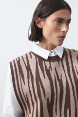 Chaleco tejido de punto con diseño estampado abstracto en tonos marrón y beige, de corte recto y cuello redondo.