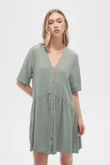 Vestido corto de algodón color verde, con cuello en V, cierre frontal de botones y diseño holgado con falda fruncida.