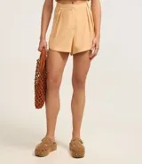 Short corto de tiro alto confeccionado en una mezcla de viscosa y lino, con diseño de cintura sastre, cierre frontal con cremallera y pliegues laterales.