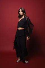 Top negro asimétrico con un hombro descubierto y manga con volado de red.