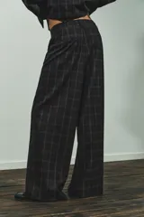Pantalón de tiro alto con diseño de cuadros, pernera recta y cintura con trabillas. Cuenta con bolsillos laterales, bolsillos de vivo en la parte posterior y cierre frontal con cremallera, botón oculto y gancho metálico.