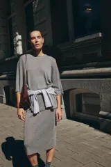 Jersey de punto gris jaspeado, de corte oversize, con cuello redondo y mangas cortas amplias.