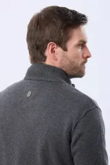 Campera tejida de lana color azul marino, con cuello alto, cierre metálico frontal y bolsillos laterales. Presenta detalles en cuero y logo bordado.