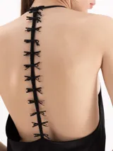Top de satín negro con escote drapeado y tirantes finos tipo halter.