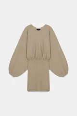 Cuerpo de punto con cuello redondo y mangas largas abullonadas. Presenta un diseño con cintura entallada y bajo ajustado.