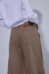 Pantalón de tiro medio y piernas anchas, confeccionado en mezcla de lino y algodón, con bolsillos delanteros y traseros con detalles de costuras pespunteadas a contratono.