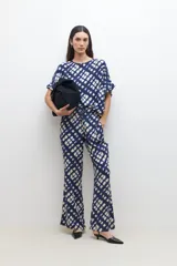 Pantalón acampanado con estampado abstracto en tonos azul marino y beige, con cintura elastizada y cordón ajustable.