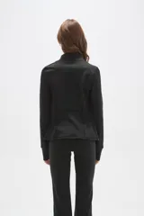 Campera deportiva negra de ajuste al cuerpo, con cierre frontal completo, cuello alto y mangas largas con orificio para el pulgar.