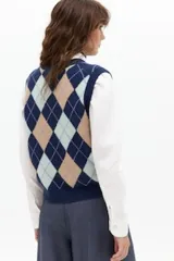 Chaleco de punto con diseño de rombos argyle en tonos gris, beige, marrón y verde, con escote en V y cierre frontal de botones.