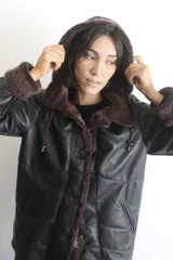 Campera de napalán de cuero genuino con interior de piel sintética, diseño con capucha desmontable, cierre frontal con botones y bolsillos laterales.