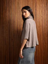 Poleron negro de tejido de punto con cuello alto doble y mangas 3/4 con puños acanalados.