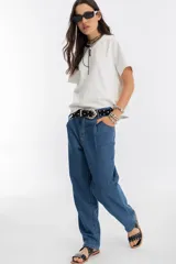 Pantalón de denim azul índigo, de tiro medio-alto, con tablas en la cintura, corte recto y bolsillos laterales y traseros.