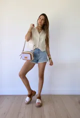 Colgante con cordón de cuero color camel y dije metálico dorado con forma de estribo.