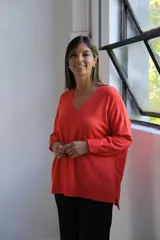 Sweater de punto color naranja, con cuello en V, manga larga y diseño holgado con tajos laterales en el ruedo.