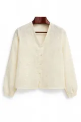 Blusa color crema de lino con bordado de flores, cuello en V, manga larga abullonada y cierre frontal con botones.