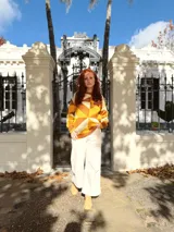 Sweater de punto con diseño geométrico en tonos mostaza, marrón y beige.