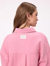 Camisa de manga larga con efecto lavado, corte oversize y cierre frontal con botones. Presenta cuello clásico y logo bordado en el pecho.