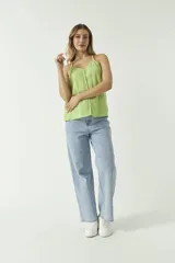 Musculosa verde manzana de algodón con textura arrugada, escote en V y cierre frontal con botones.