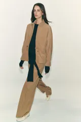 Pantalón blanco de tiro alto con pierna ancha y cordón ajustable en la cintura. Presenta bolsillos laterales y falsos bolsillos de vivo en la parte trasera.