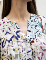 Blusa estampada marca Grand & Greene, con cuello a la base y escote en V. Tiene mangas 3/4 con puños elásticos fruncidos.