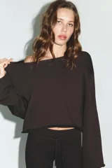 Sudadera de algodón con cuello barco y mangas largas acampanadas con terminación evasé. Presenta un diseño minimalista con bajo recto y bordes sin costuras visibles.