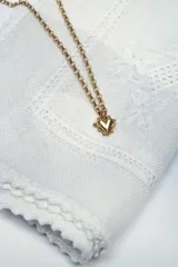 Collar de plata con baño de oro de 24 quilates, compuesto por una cadena de eslabones rolo y un dije en forma de corazón.