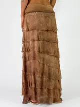 Pollera larga de viscosa color beige con diseño de múltiples capas y volados superpuestos de terminación rústica deshilachada.
