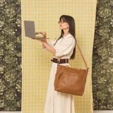 Cartera grande de cuerina negra tipo tote, con asas de mano y correa larga ajustable y desmontable. Cuenta con bolsillos exteriores con cierre en la parte frontal y trasera, además de bolsillos internos.