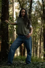 Chaleco corto de punto color verde oliva, con cuello amplio y aberturas laterales con lazos para ajustar.